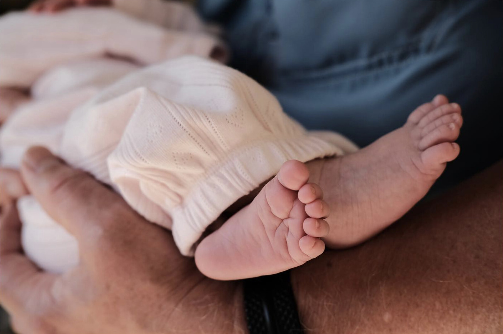 Close-up of a baby's feet resting in an adult's hands